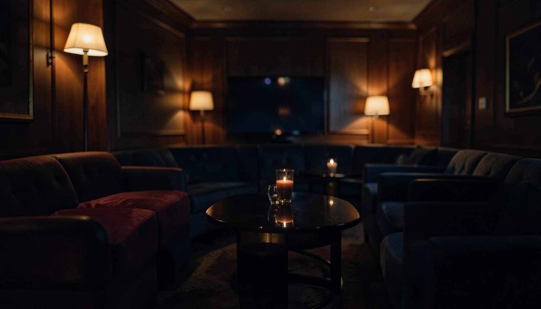 Dimly lit lounge with warm amber and deep navy tones, soft ambient glow reflecting off polished surfaces, evoking a calm and focused atmosphere